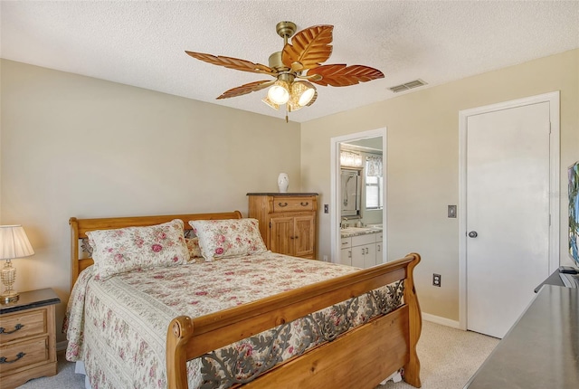 carpeted bedroom with ceiling fan, a textured ceiling, and ensuite bath