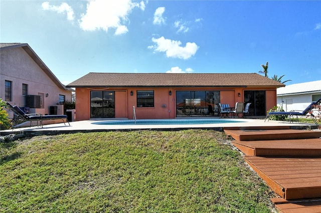 rear view of property with central air condition unit, a patio area, and a yard