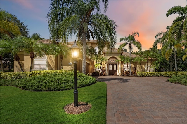 mediterranean / spanish house featuring a lawn