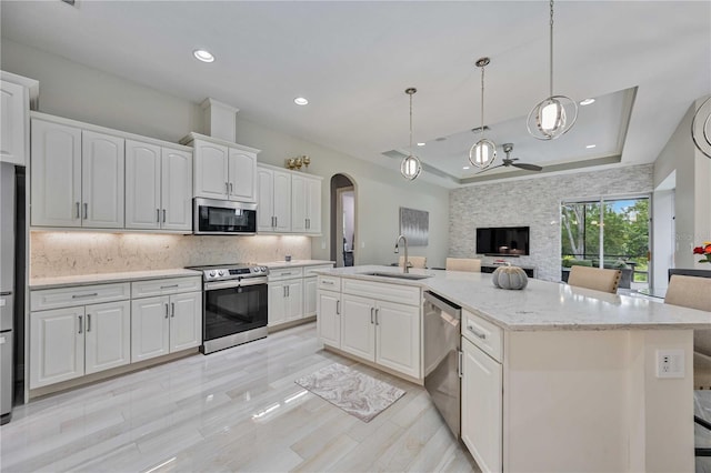 kitchen with white cabinetry, sink, a kitchen island with sink, and appliances with stainless steel finishes