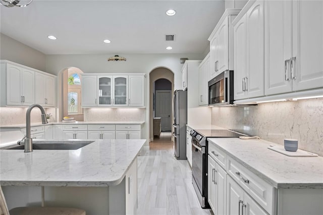 kitchen featuring sink, stainless steel appliances, white cabinets, and light stone countertops