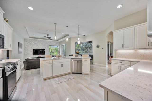 kitchen with pendant lighting, white cabinetry, stainless steel dishwasher, and electric range oven