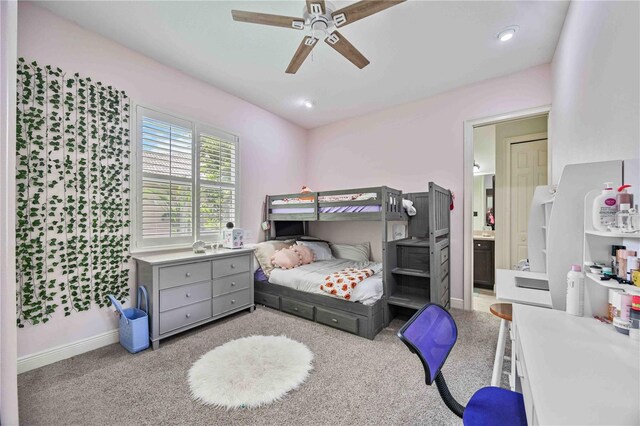 bedroom with light colored carpet, ceiling fan, and ensuite bathroom