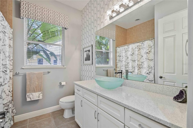 bathroom with a healthy amount of sunlight, tile patterned floors, vanity, and toilet