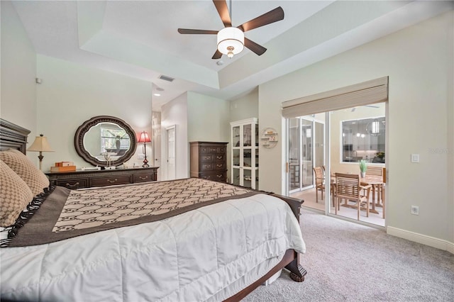 bedroom with ceiling fan, carpet flooring, access to exterior, and a raised ceiling