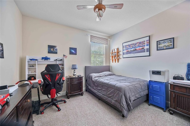 bedroom featuring ceiling fan, light colored carpet, and a textured ceiling