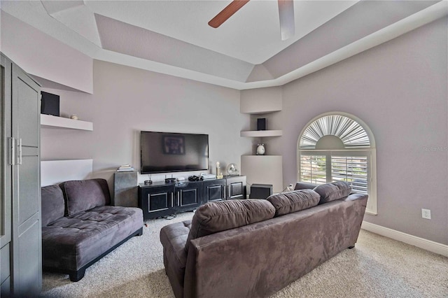 carpeted living room featuring a raised ceiling and ceiling fan