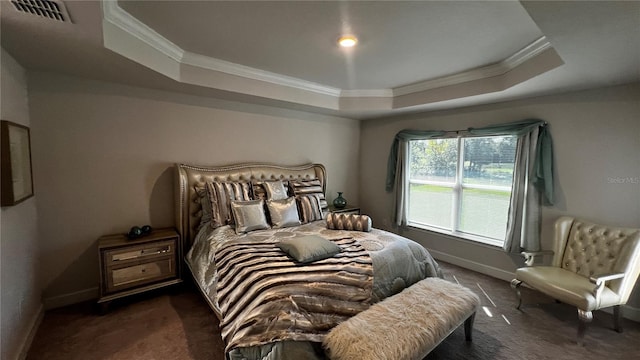 carpeted bedroom featuring ornamental molding and a tray ceiling