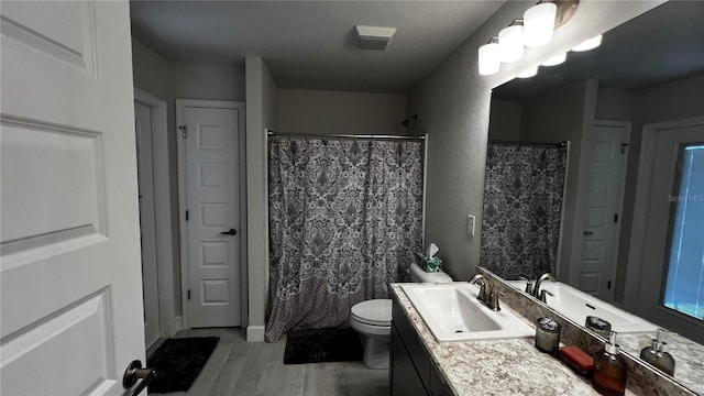 bathroom featuring vanity, a shower with shower curtain, hardwood / wood-style flooring, and toilet