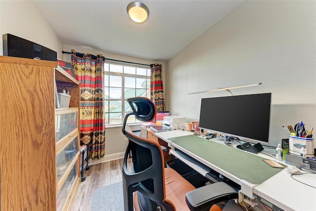 office area featuring vaulted ceiling and light hardwood / wood-style flooring