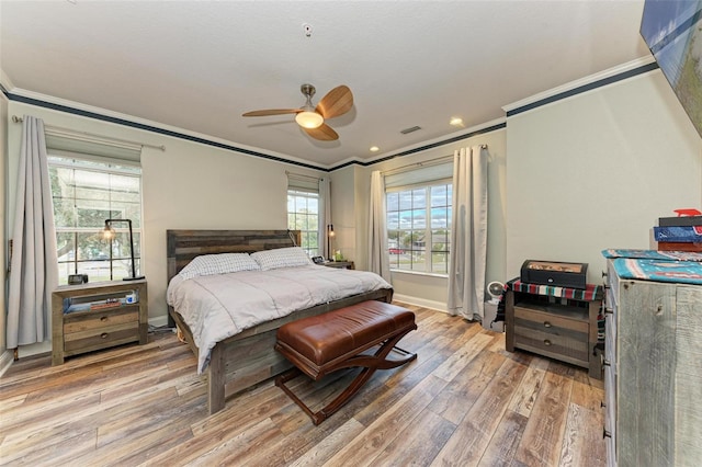 bedroom with hardwood / wood-style flooring, ceiling fan, and crown molding