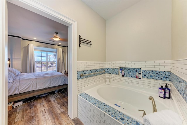 bathroom with a relaxing tiled tub and hardwood / wood-style floors