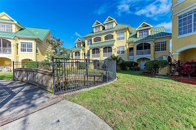 view of property with a front lawn and a balcony