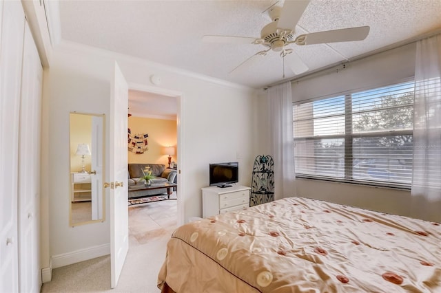 bedroom featuring a textured ceiling, light colored carpet, ceiling fan, and ornamental molding