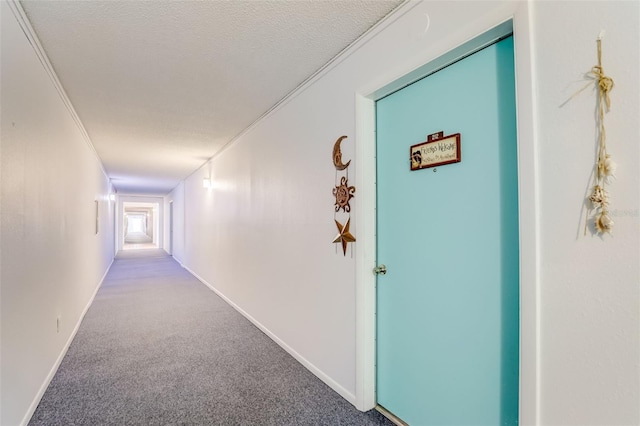 hallway featuring a textured ceiling, crown molding, and light carpet