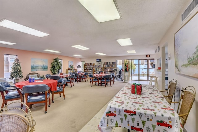 carpeted dining area with a textured ceiling