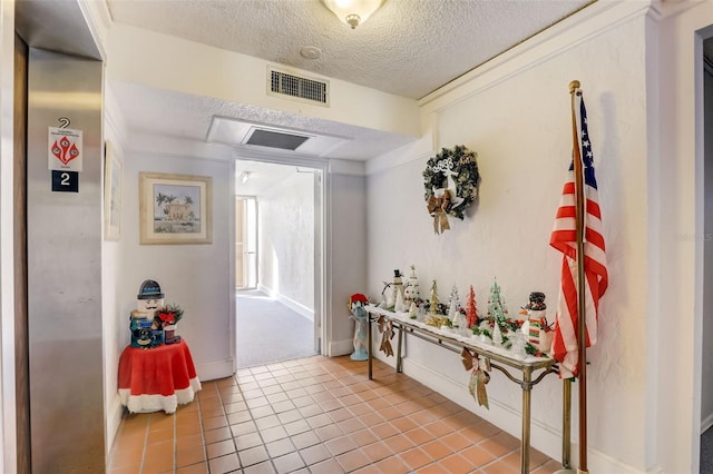 hallway featuring light tile patterned floors and a textured ceiling