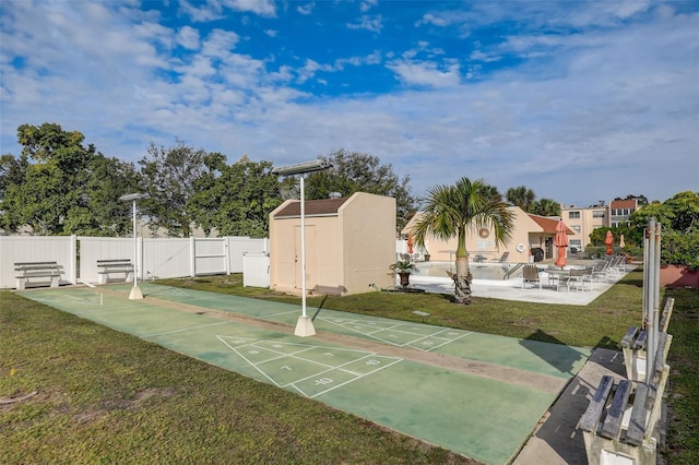 view of home's community featuring a yard and a storage unit