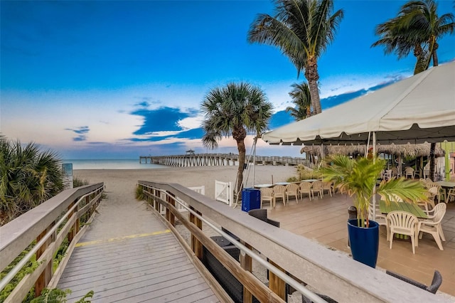 dock area with a beach view and a water view