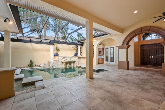 view of patio / terrace featuring french doors, glass enclosure, and ceiling fan