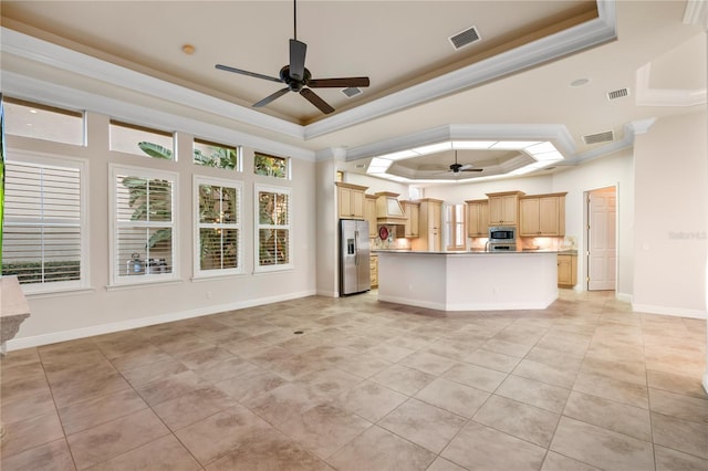 kitchen featuring light brown cabinets, a raised ceiling, ornamental molding, and appliances with stainless steel finishes