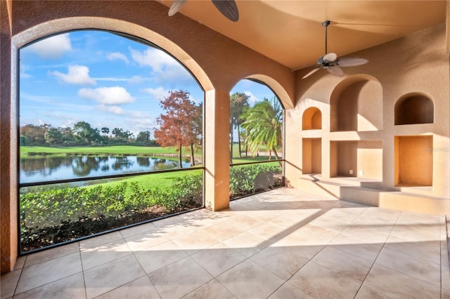 view of patio with a water view and ceiling fan