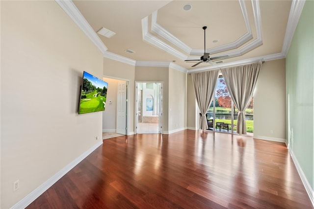 unfurnished room with wood-type flooring, a raised ceiling, ceiling fan, and crown molding