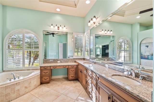 bathroom with tile patterned flooring, vanity, tiled bath, and ceiling fan