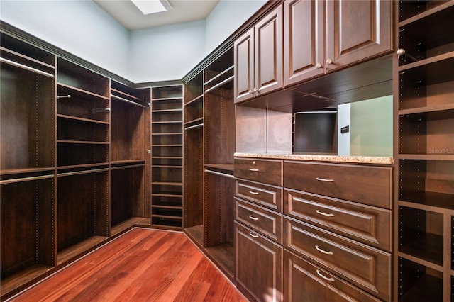 walk in closet with dark hardwood / wood-style flooring