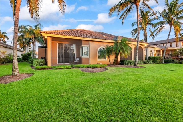 rear view of property featuring a lawn