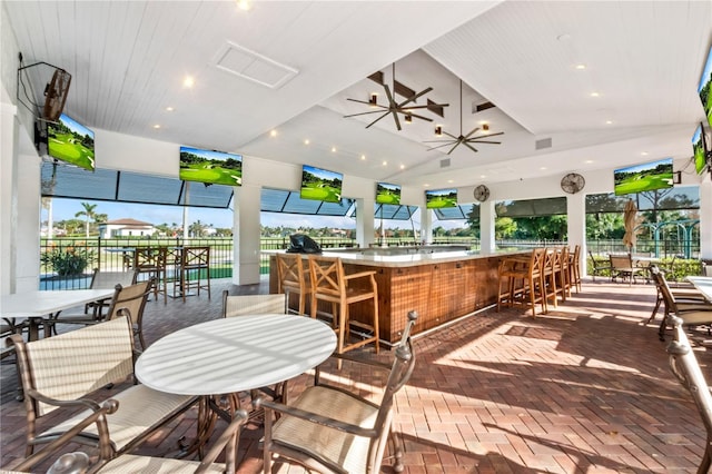 view of patio featuring ceiling fan and exterior bar