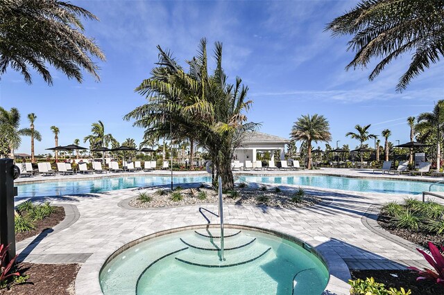 view of swimming pool featuring a community hot tub and a patio area