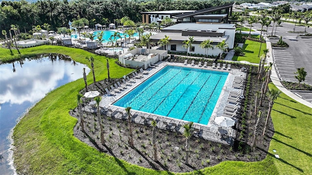 view of pool with a lawn and a water view