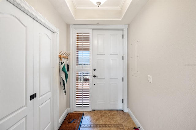 entryway with light tile patterned flooring, a raised ceiling, and baseboards