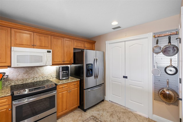 kitchen with brown cabinets, visible vents, and stainless steel appliances