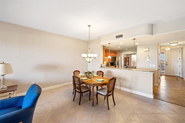 dining space featuring an inviting chandelier, light tile patterned floors, visible vents, and baseboards