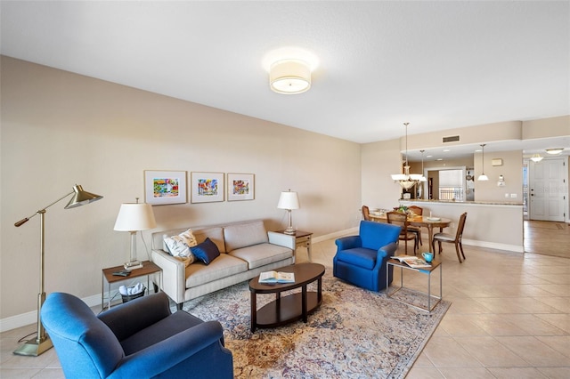 tiled living room with a notable chandelier