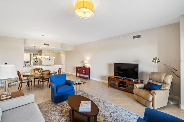 living room with light tile patterned flooring and a notable chandelier