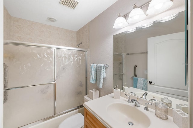 bathroom featuring toilet, visible vents, a textured wall, and shower / bath combination with glass door
