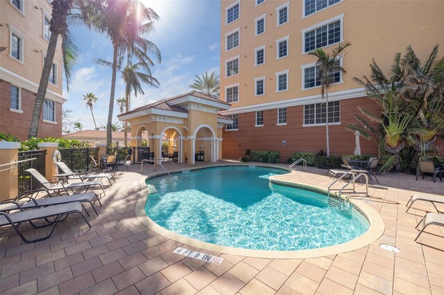 community pool with fence and a patio area