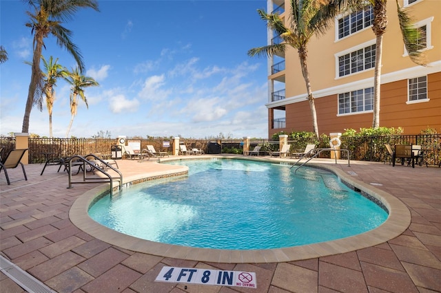 community pool featuring a patio and fence