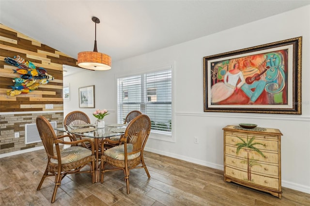 dining room featuring wood walls, vaulted ceiling, and hardwood / wood-style floors