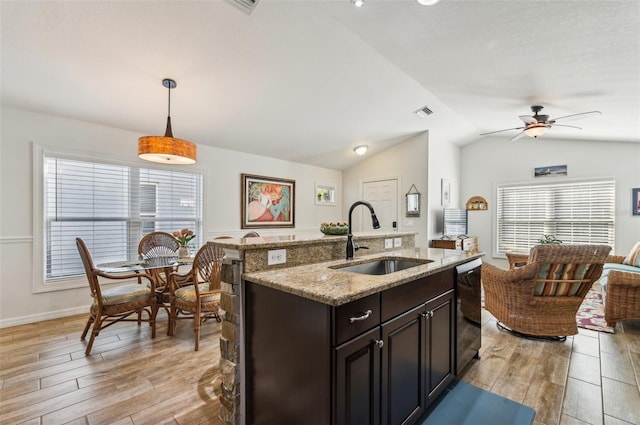 kitchen with light hardwood / wood-style flooring, sink, hanging light fixtures, and vaulted ceiling