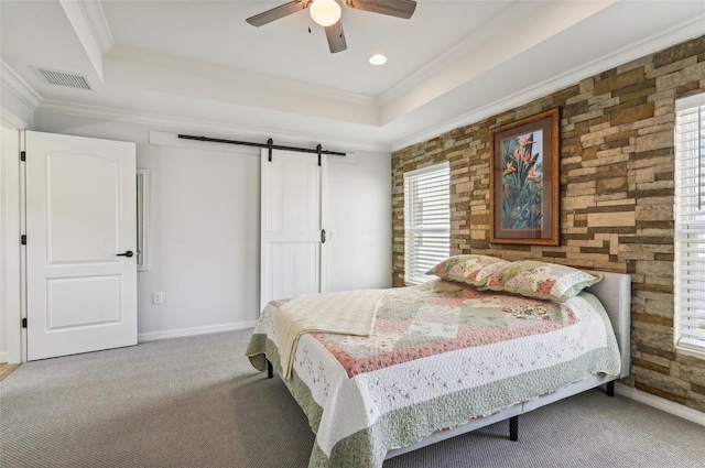 bedroom with carpet, a raised ceiling, ceiling fan, a barn door, and crown molding