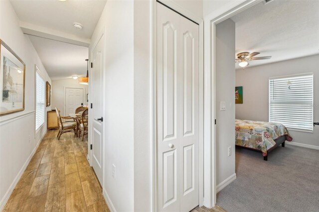 corridor with lofted ceiling and light hardwood / wood-style flooring