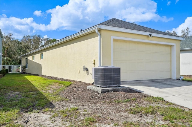 view of side of home featuring central AC unit and a garage