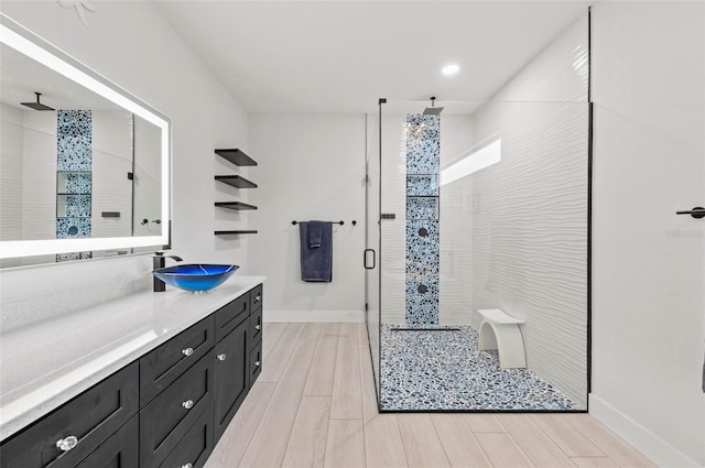 bathroom featuring hardwood / wood-style flooring, vanity, and walk in shower