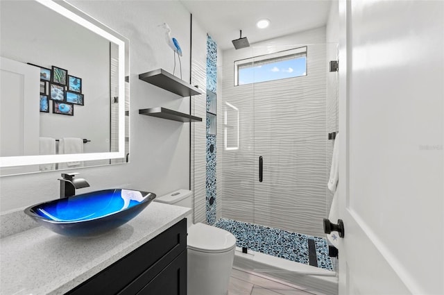 bathroom featuring hardwood / wood-style floors, vanity, lofted ceiling, toilet, and a shower with shower door