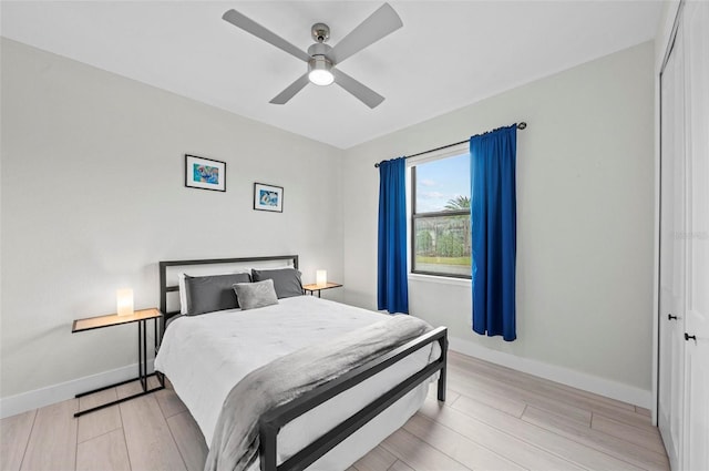 bedroom with ceiling fan, a closet, and light hardwood / wood-style flooring