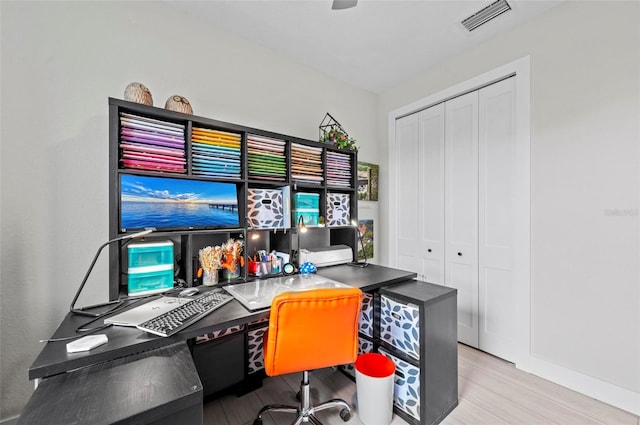 home office with light hardwood / wood-style floors